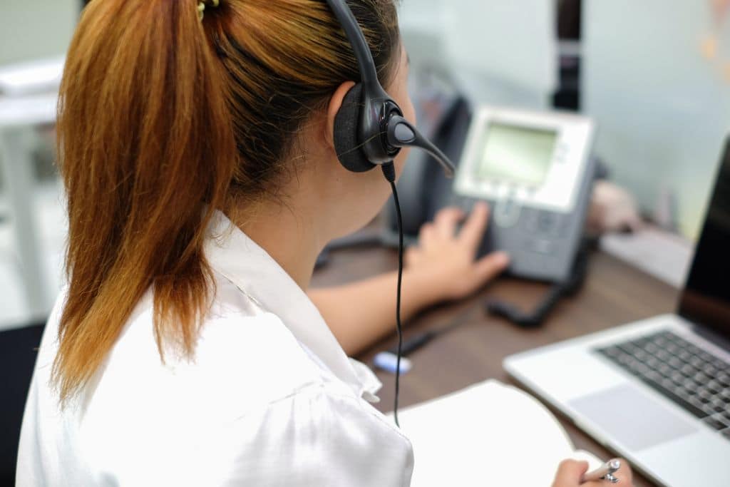 what is hosted voip - woman using voip phone system at desk